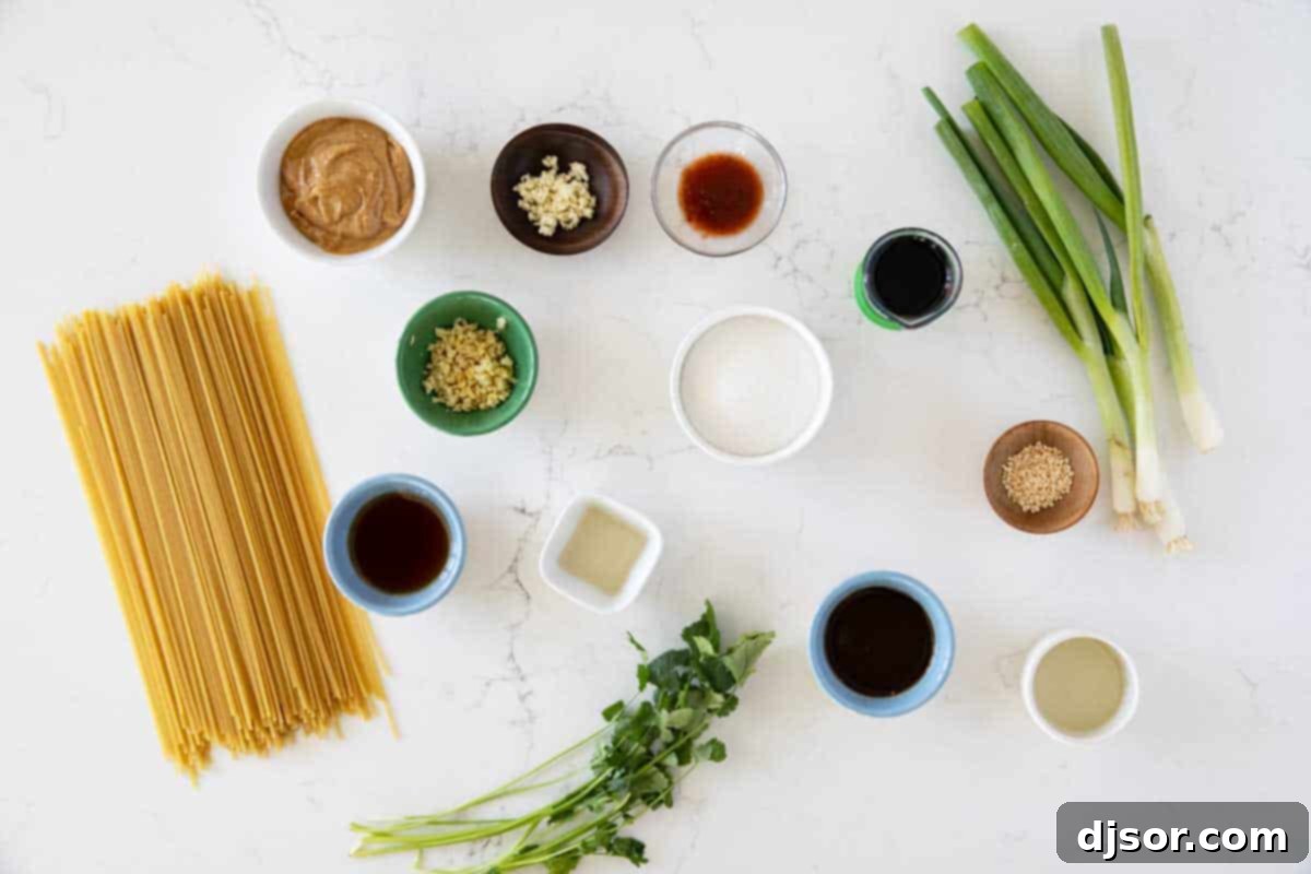Arrangement of fresh ingredients including peanut butter, soy sauce, ginger, garlic, and sriracha, essential for making delicious Thai Peanut Noodles.
