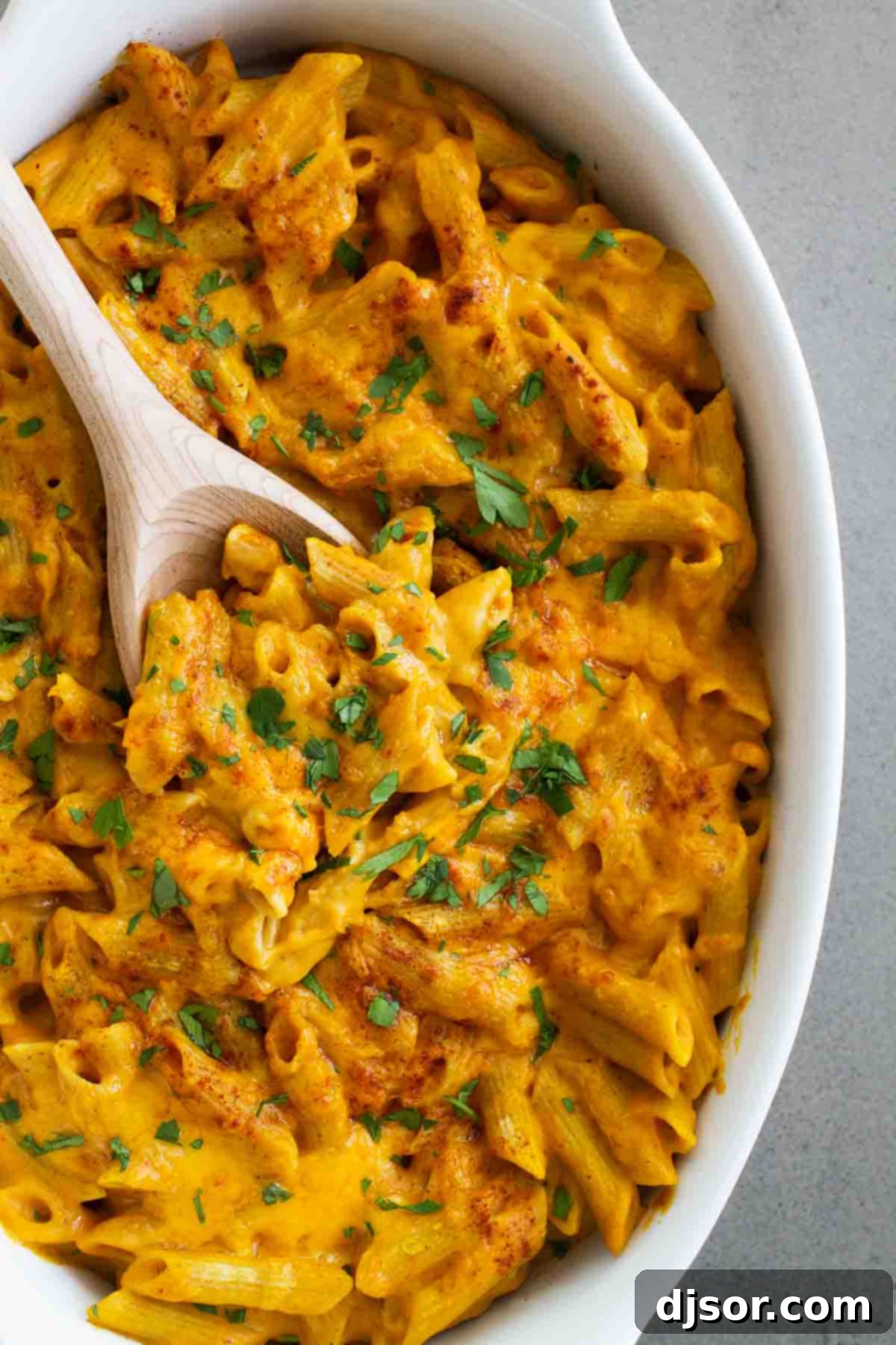 Mac and cheese made with pumpkin and cheddar topped with parsley.