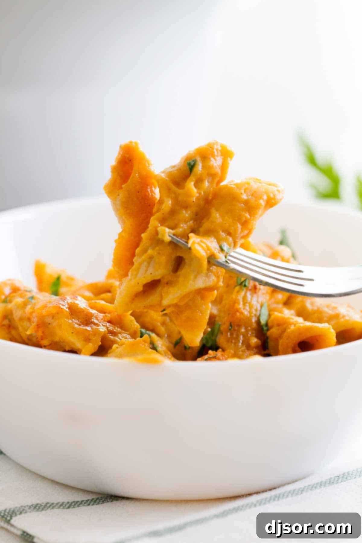 Pumpkin cheddar mac and cheese on a fork.