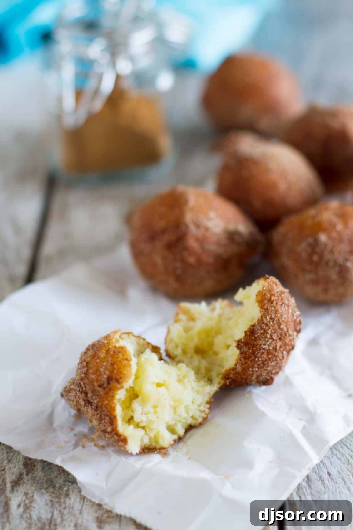 A delicate ricotta doughnut, broken in half to reveal its light, airy, and moist interior texture.