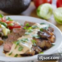 Zesty Mexican Steaks with Creamy Chile Queso 4 Plate with Mexican Spiced Steaks with Chile Con Queso with tomato and avocado salad on the side.