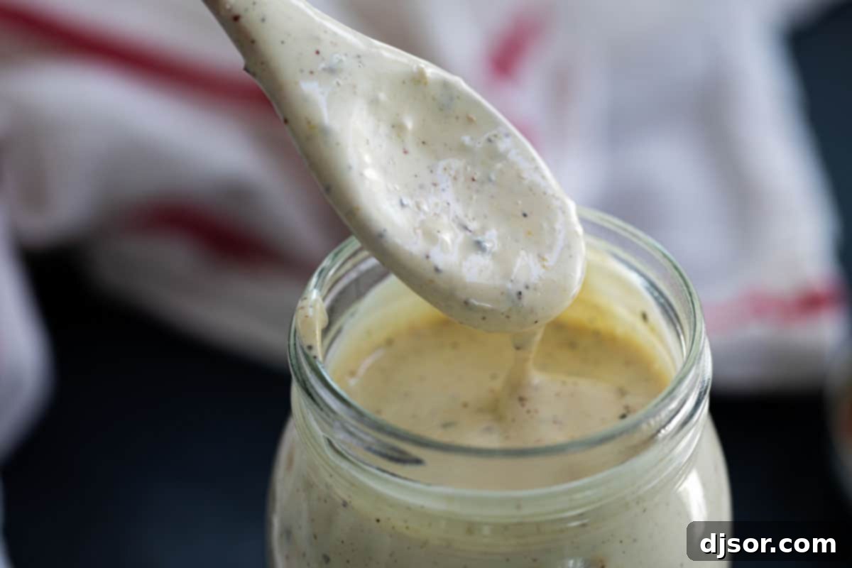 Tangy Alabama White BBQ 3 A glass jar filled with creamy, tangy Alabama White BBQ Sauce, ready for serving.