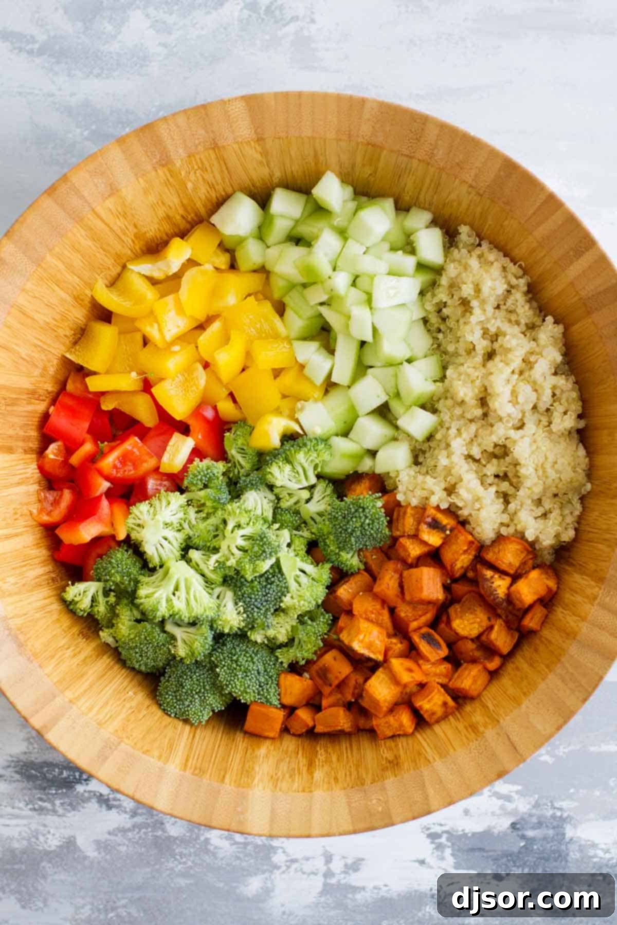 Close-up of fresh ingredients for Quinoa and Roasted Sweet Potato Salad including diced sweet potatoes, quinoa, and colorful vegetables.