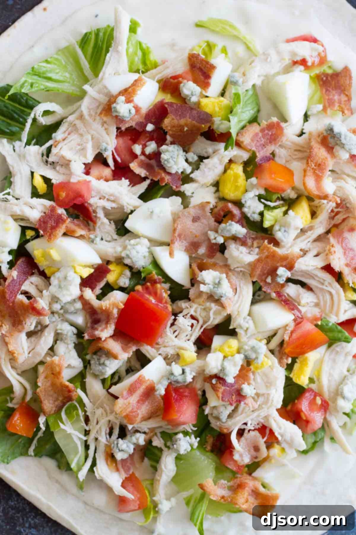 Detailed shot of the fresh and cooked ingredients for Chicken Cobb Salad Wraps, highlighting texture and color.