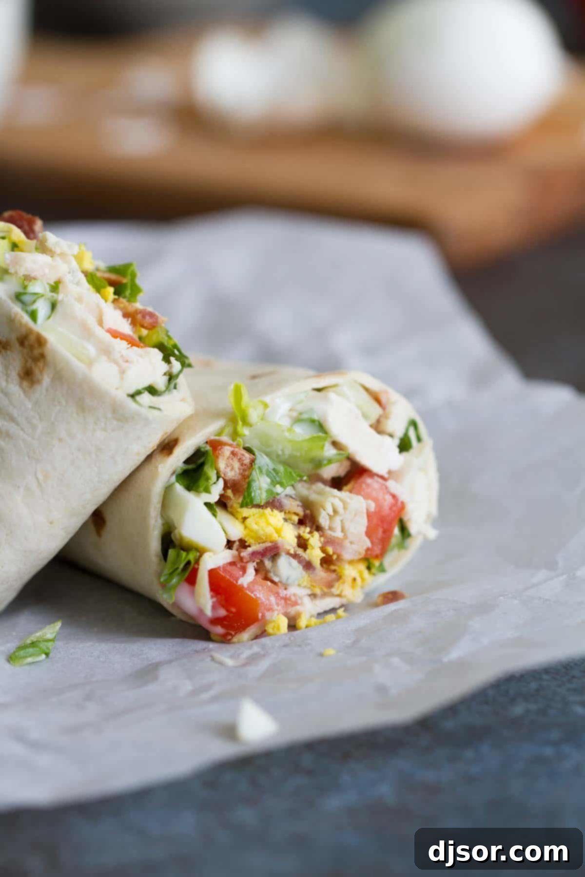 A perfectly rolled Chicken Cobb Salad Wrap, ready to be enjoyed as a hearty meal.