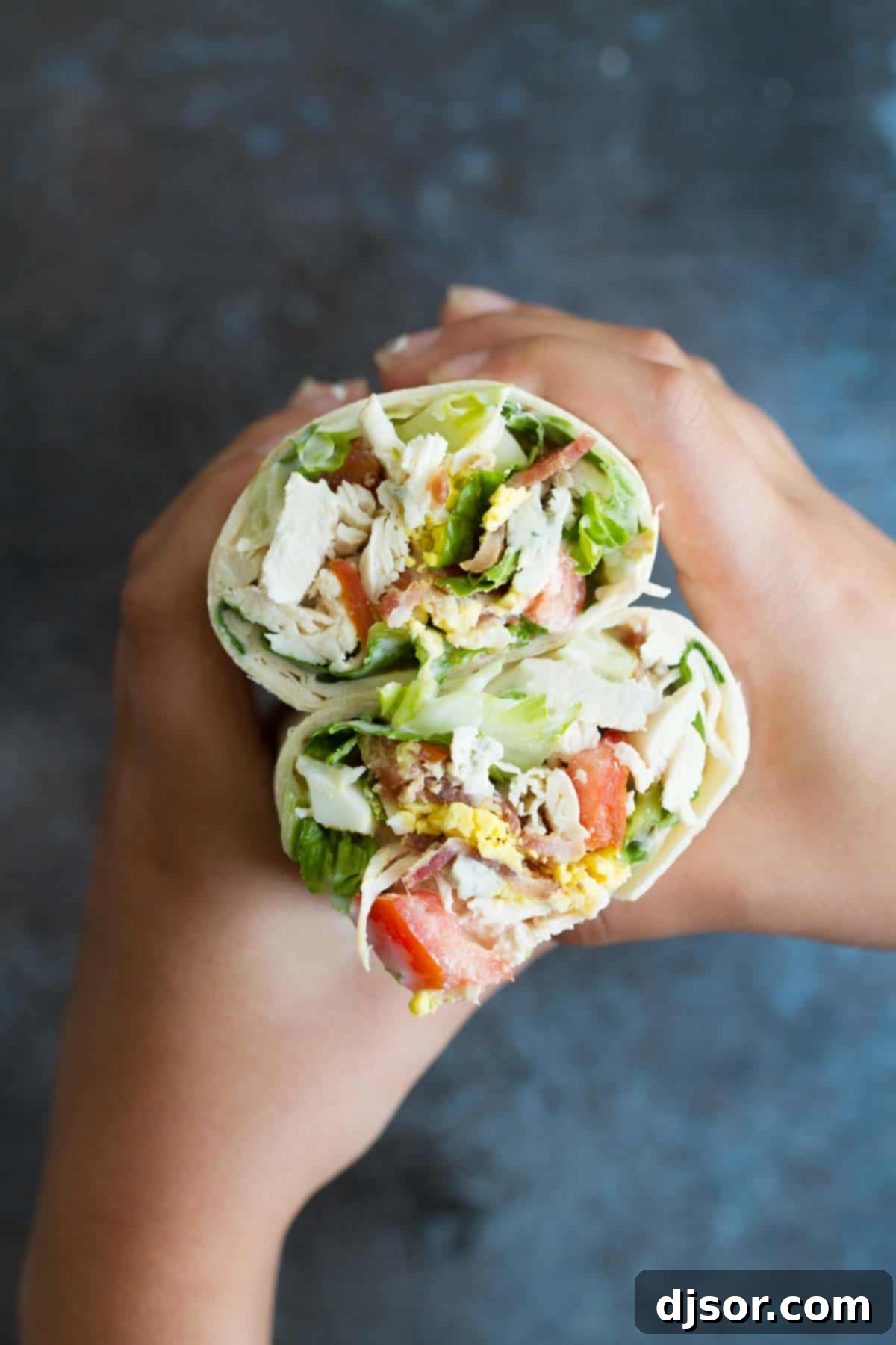 A plate of Chicken Cobb Salad Wraps, cut in half, showcasing an easy and delicious lunch idea.