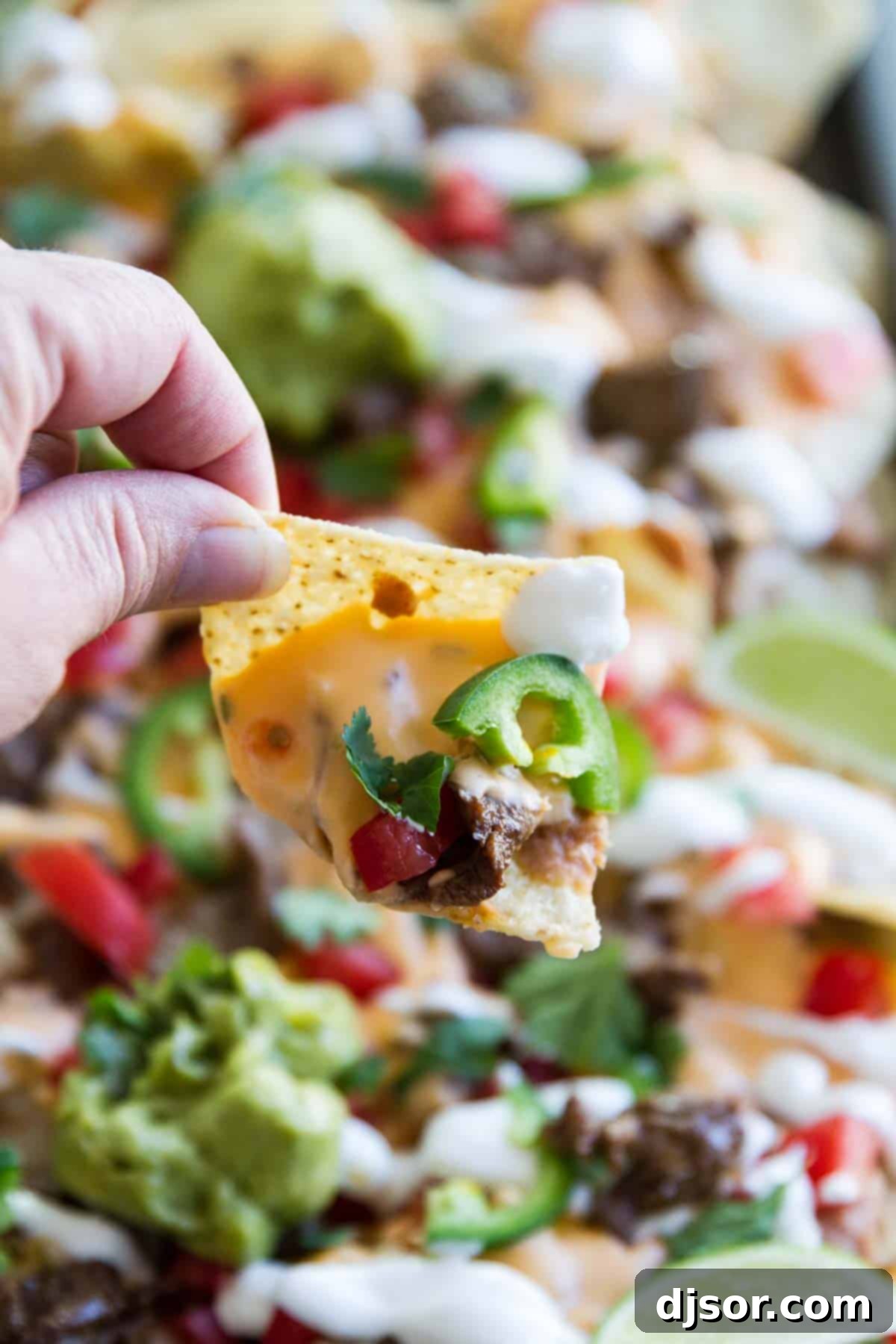 Sheet Pan Steak Nachos Supreme presented as a perfect tailgating recipe.
