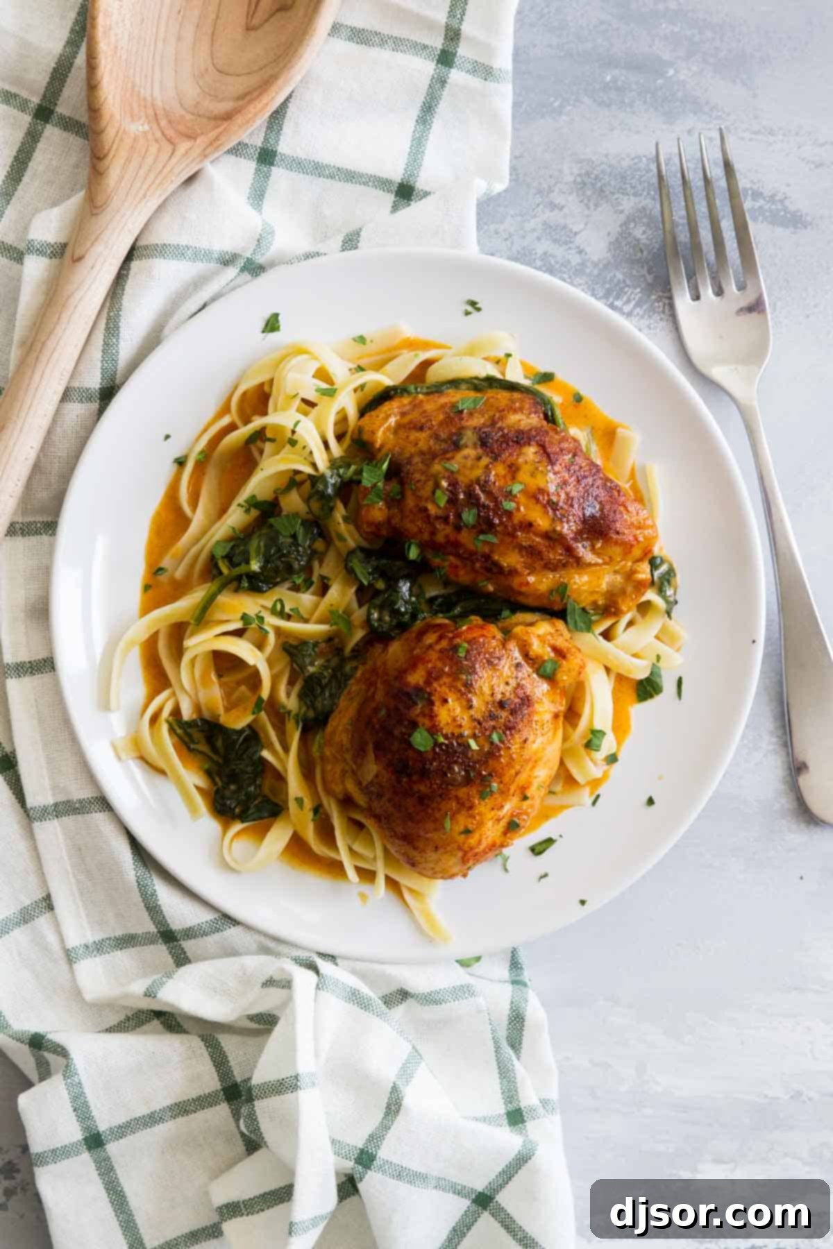 Restaurant quality at home - these Garlic Paprika Instant Pot Chicken Thighs make even a weeknight special! Seasoned boneless chicken thighs are served in a delicious cream sauce - perfect for a date night in! Serving of Garlic Paprika Chicken Thighs served over past on a plate.