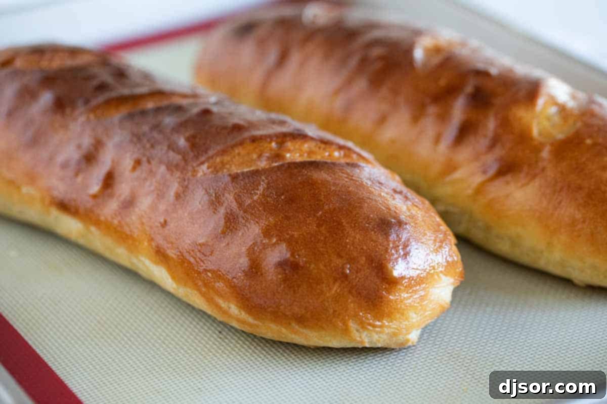 Freshly Baked French Bread Pair Two freshly baked, golden-brown French bread loaves cooling on a baking sheet