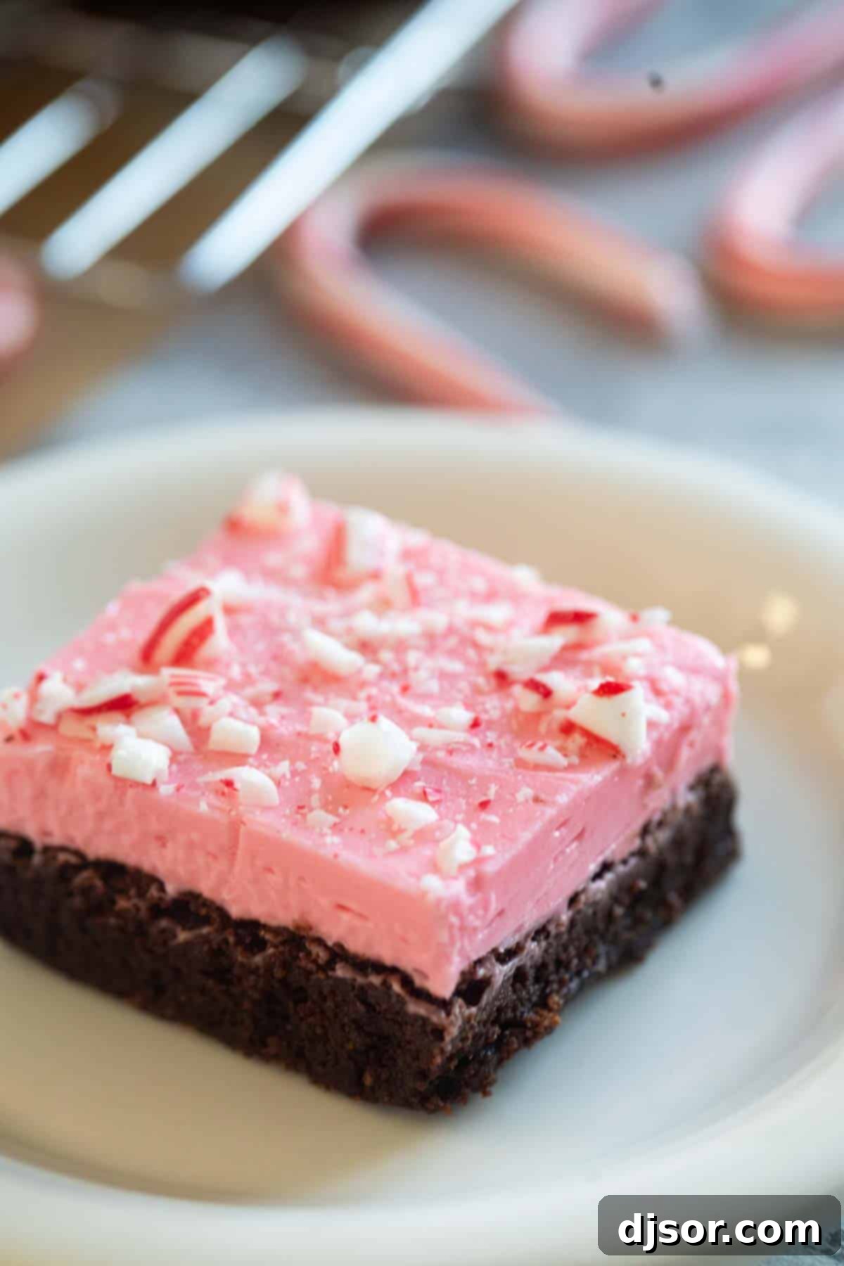 Chocolate Peppermint Dream 8 A single, perfectly frosted peppermint brownie, topped with crunchy candy canes, ready to be enjoyed as a holiday treat.
