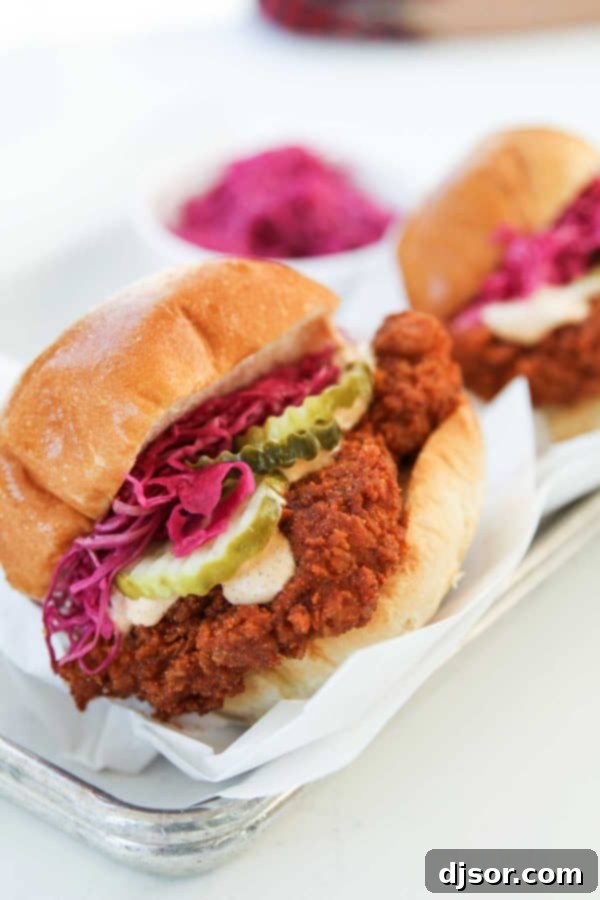 A close-up of a hot chicken sandwich with pickles, served on a bun, from Pretty Bird in Salt Lake City.
