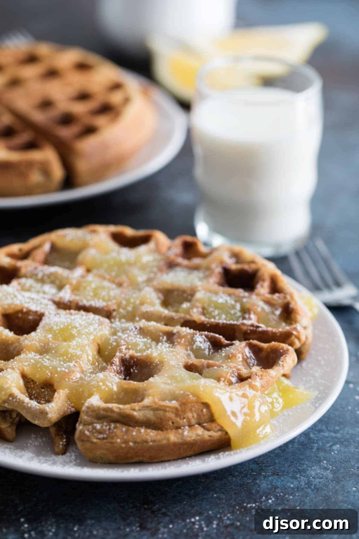 Homemade Gingerbread Waffles drizzled with bright Lemon Sauce, a perfect holiday breakfast.