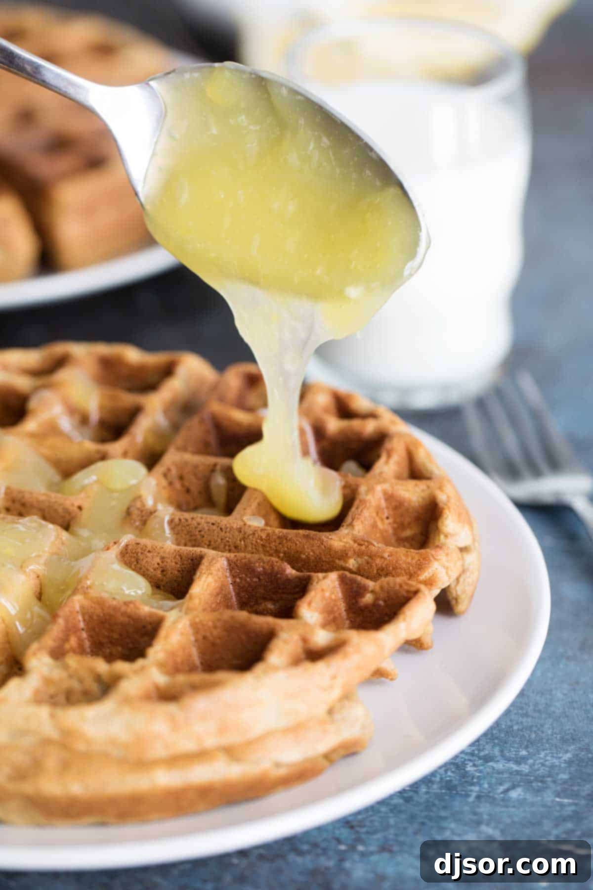 Smooth, glossy lemon sauce poured into a white serving dish, ready for waffles.