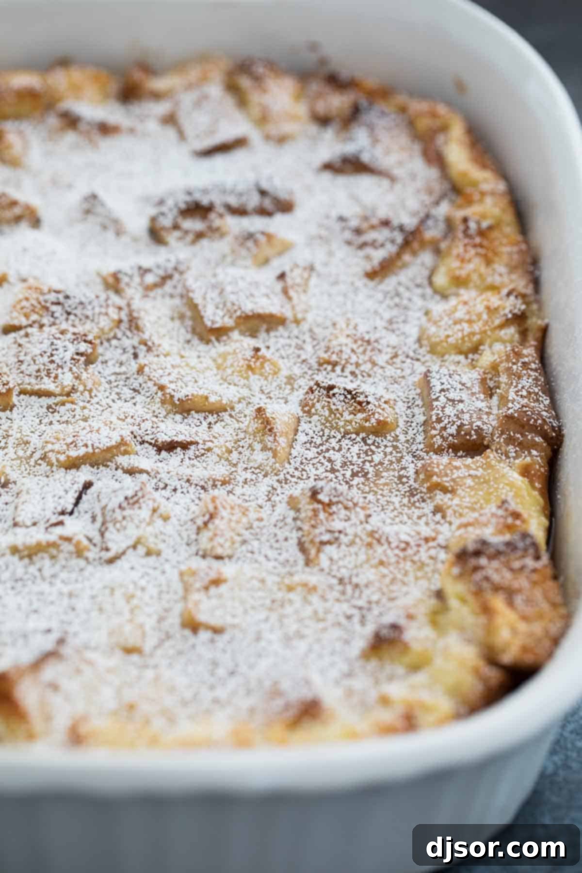 casserole dish with French Toast Casserole sprinkled with powdered sugar