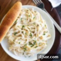 Quick and Creamy Alfredo Sauce 2 overhead view of Easy Alfredo Sauce and pasta on a plate with a breadstick