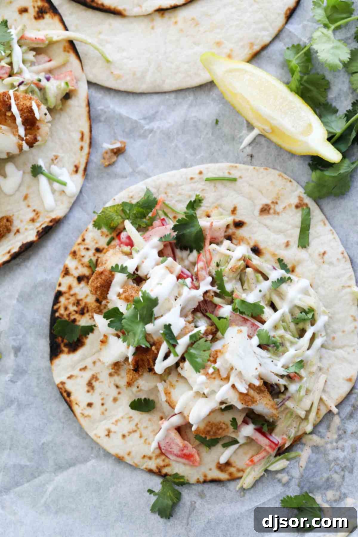 Assembling Flavorful Cajun Fish Tacos Cajun-spiced fish nestled in flour tortillas, topped with fresh slaw.