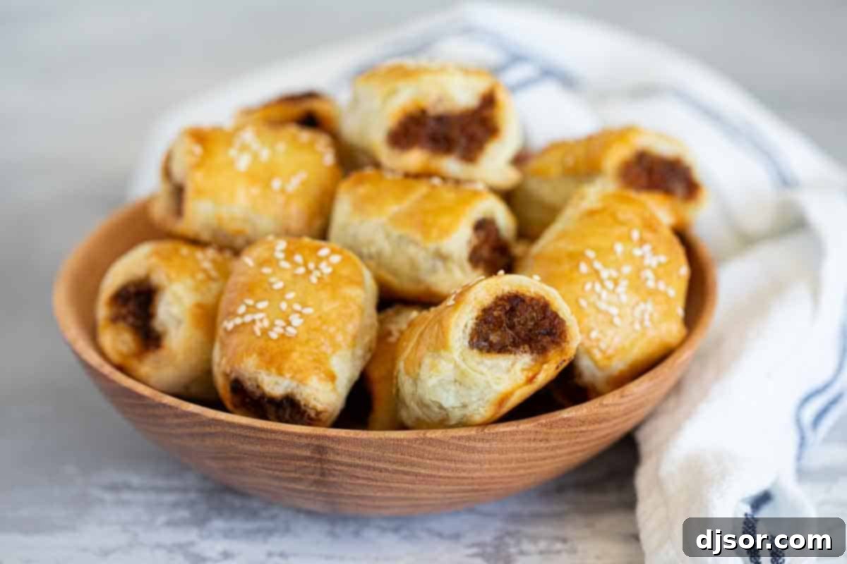 Sausage Rolls served in a rustic wooden bowl. A wooden bowl filled with delicious, golden-brown sausage rolls.