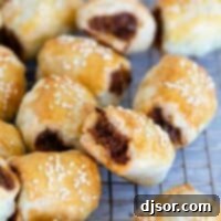 Flaky Sausage Rolls 2 Sausage Rolls on a cooling rack, stacked next to each other.