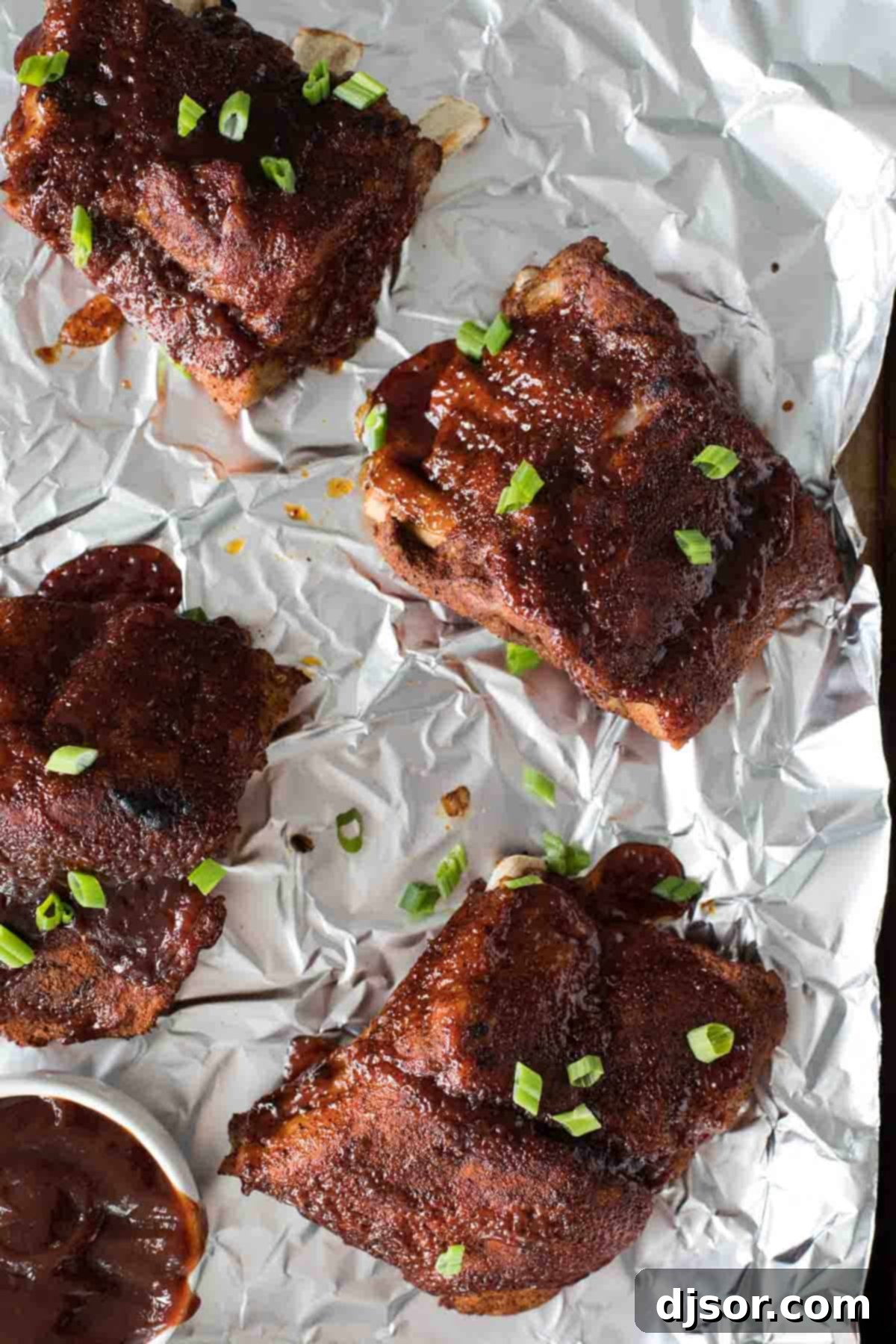 Overhead view of seasoned baby back ribs sections, ready to be placed in the Instant Pot, on a sheet of aluminum foil.
