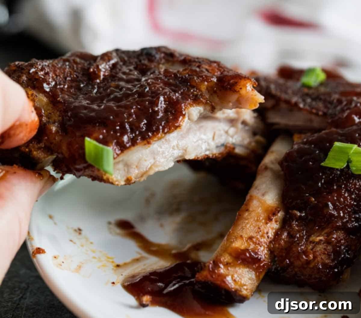 Close-up photo of the succulent, juicy texture of Instant Pot Ribs, showing the meat easily pulling from the bone.