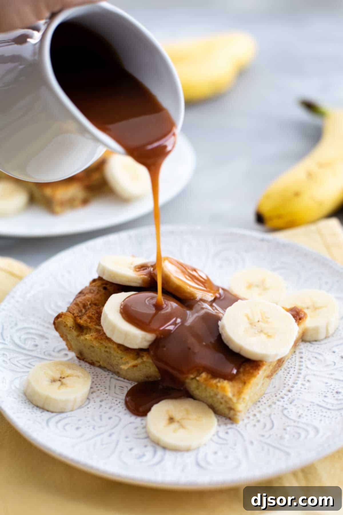 Brioche French Toast with Homemade Salted Caramel Homemade Salted Caramel sauce being drizzled generously over a stack of Brioche French Toast, ready to be served.
