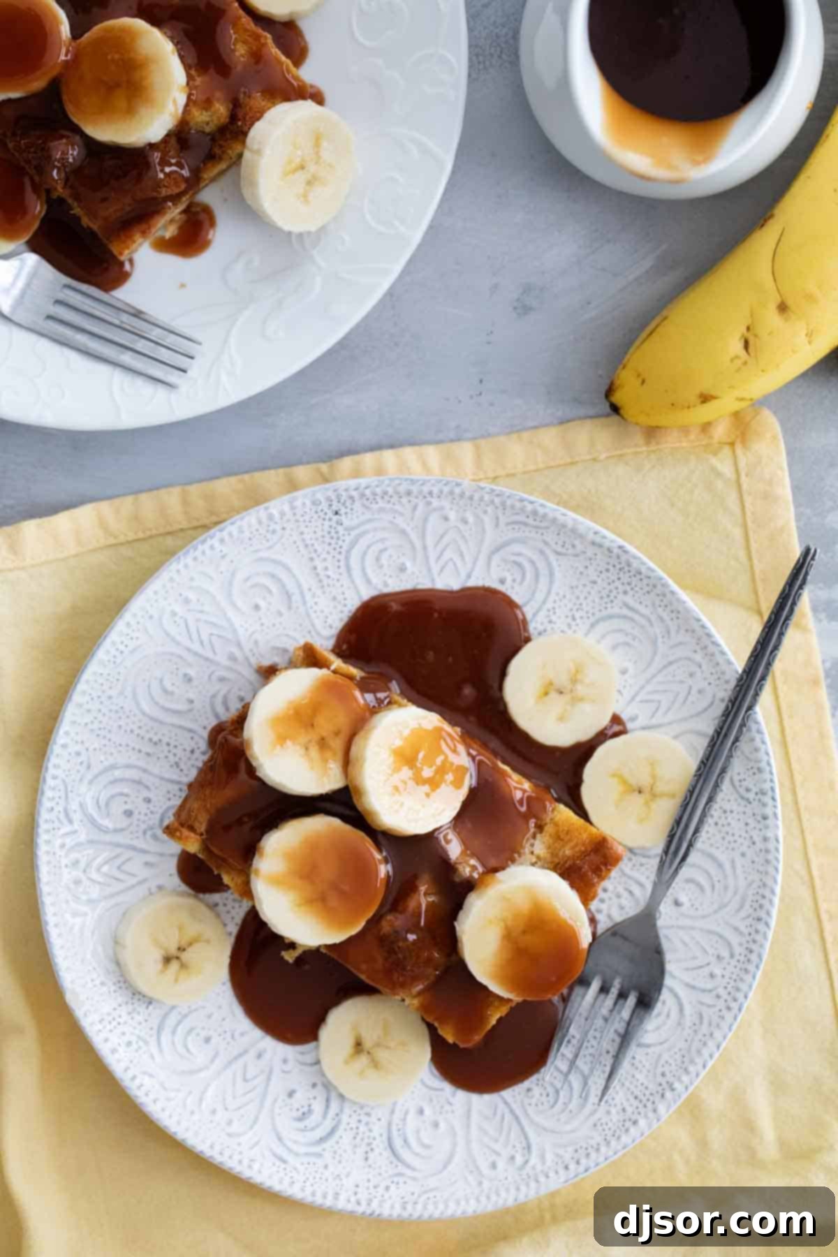 Decadent Brioche French Toast with Caramel and Bananas Brioche French Toast with Salted Caramel and fresh Bananas. A serving of French toast casserole generously topped with golden salted caramel and vibrant banana slices.