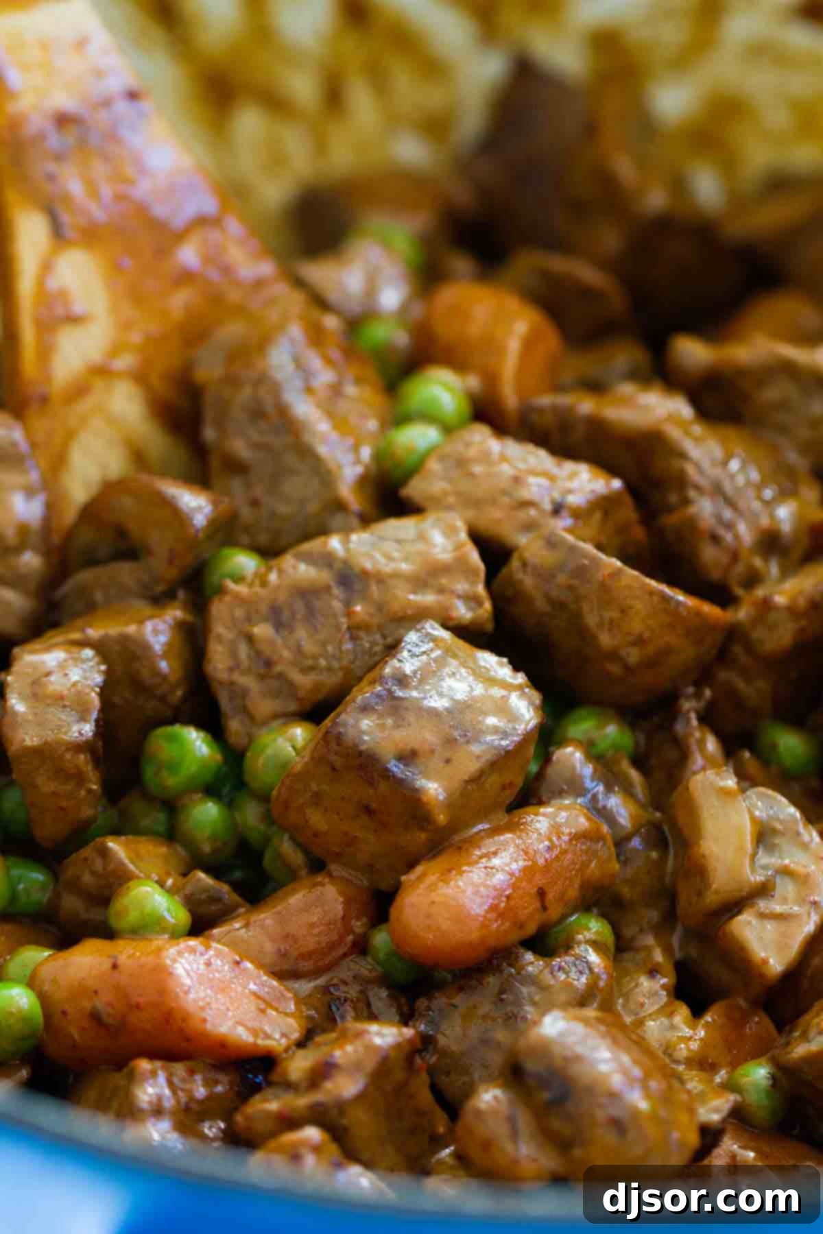 Chili Beef and Vegetables in a pot with a wooden spoon, showcasing the rich colors and textures of the dish.