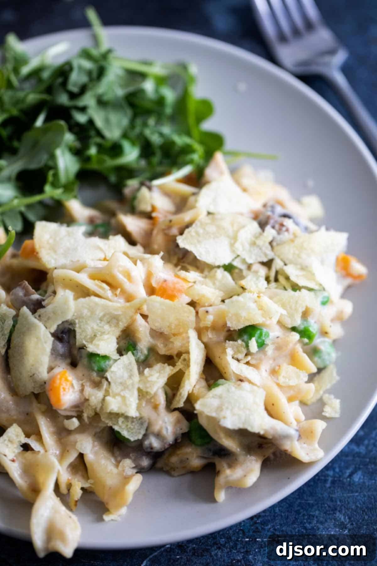 Creamy, cheesy and always comforting, this Instant Pot Tuna Noodle Casserole is so easy you’ll never bake it again. And bonus - this recipe is made from scratch! The best Instant Pot Tuna Noodle Casserole on a white plate, topped with crushed potato chips.
