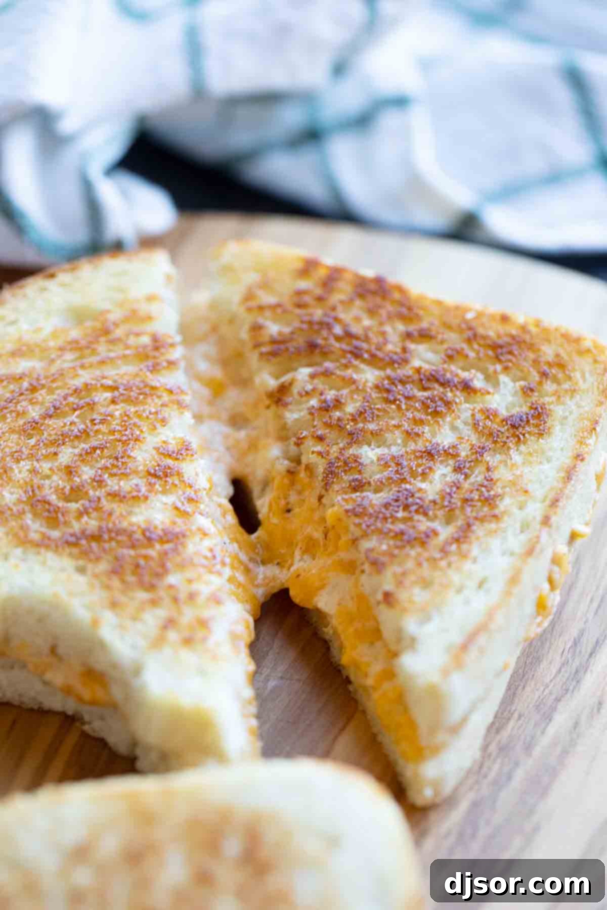 sliced grilled cheese sandwich showing gooey cheese pulling apart