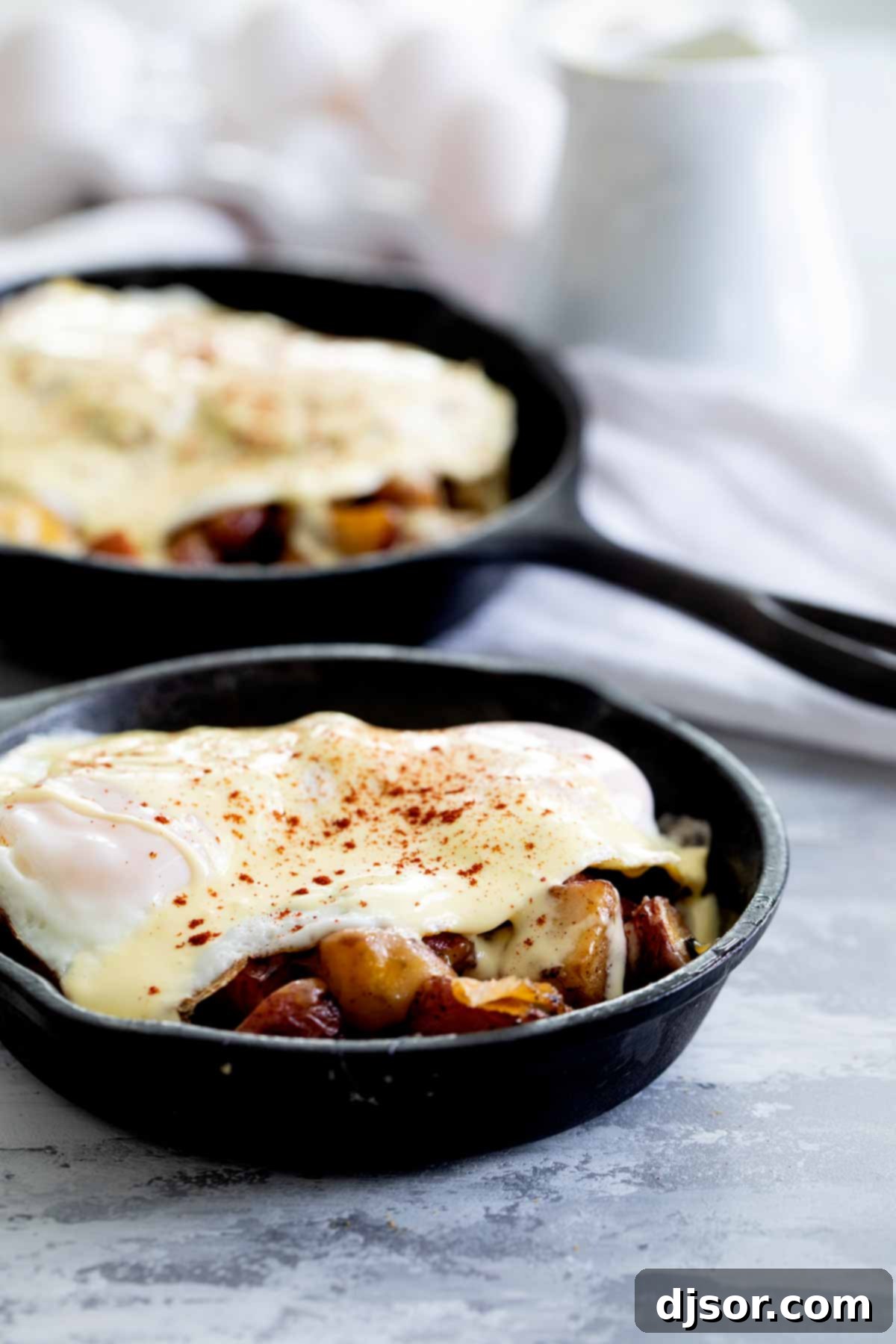 A close-up of the Meat and Potatoes Breakfast Skillet, topped with a perfectly cooked over easy egg and a sprinkle of paprika.