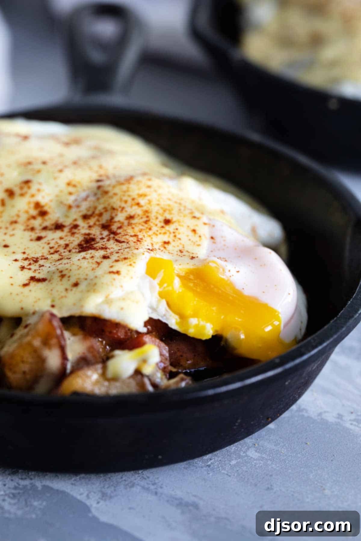 A sunny-side up egg sitting atop a rich Meat and Potatoes Breakfast Skillet, ready to be enjoyed.