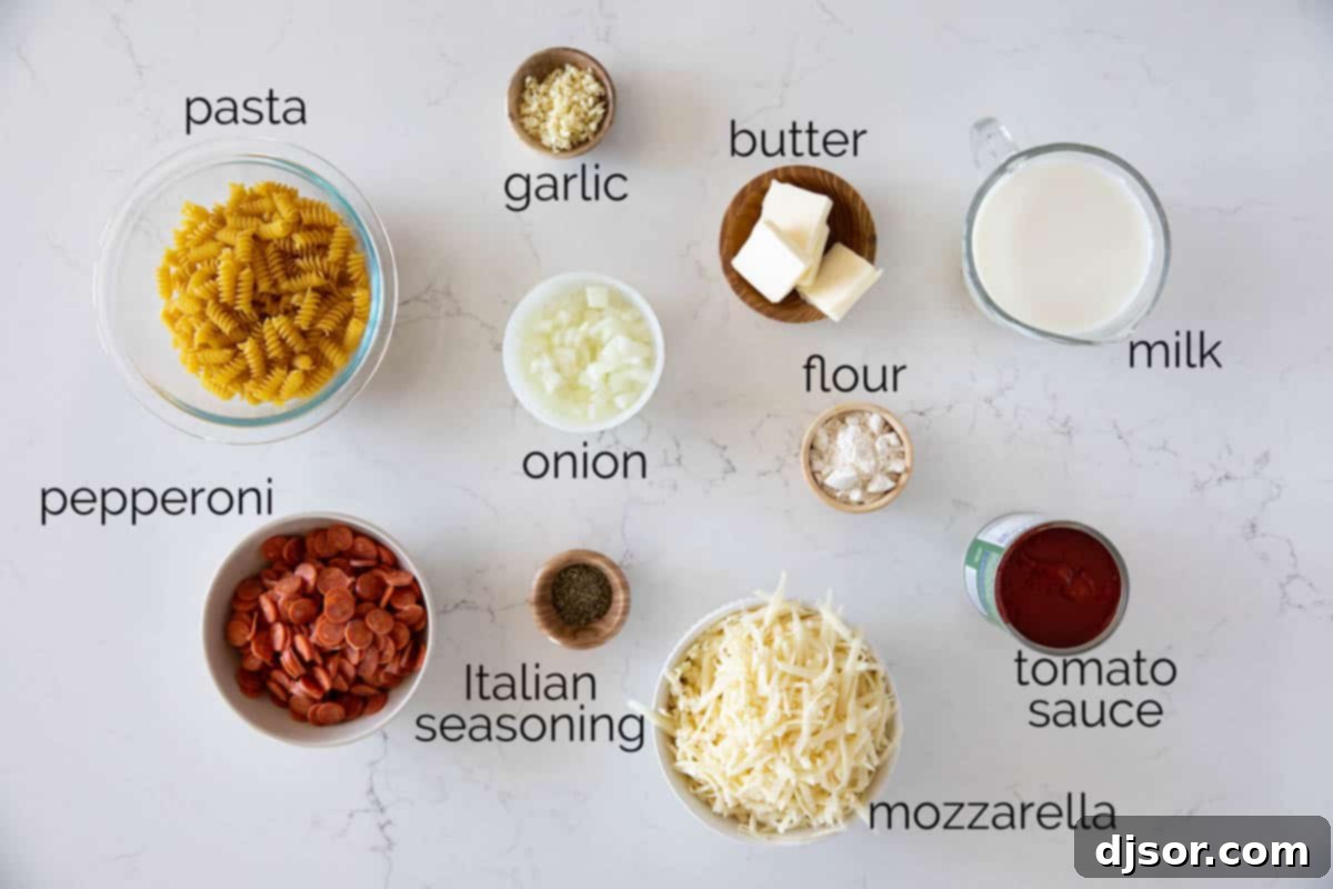 Fresh ingredients laid out for making pizza pasta, including a box of rotini, cans of tomato sauce, a block of mozzarella, and a pack of mini pepperoni.