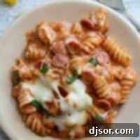 Plate full of pizza pasta with mini pepperoni and mozzarella cheese.