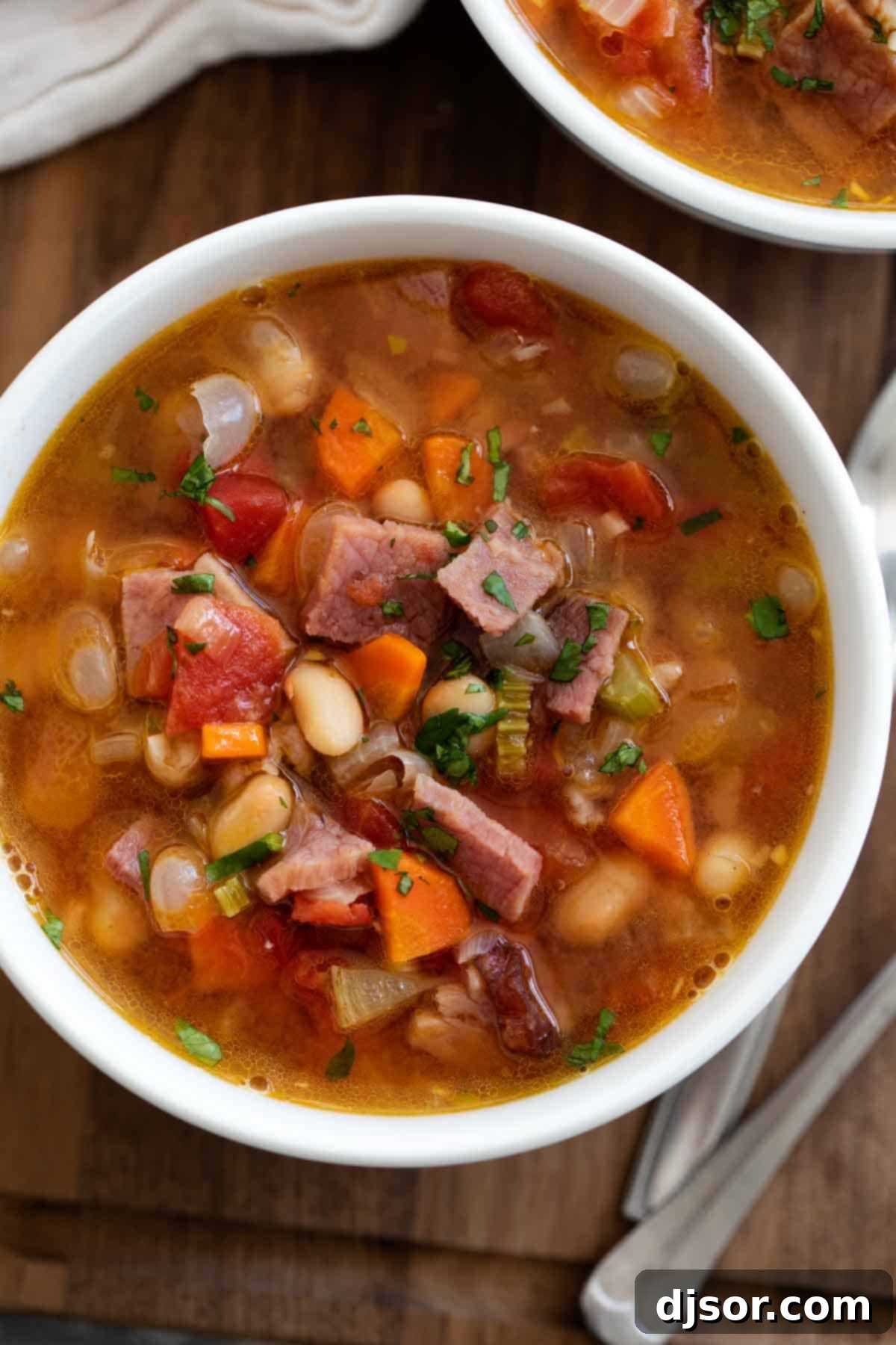 Hearty Ham and Bean Soup, a perfect comforting meal for chilly days. A steaming bowl of homemade Ham and Bean Soup, garnished with fresh herbs, ready to be enjoyed.