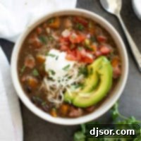 Bowl of Black Bean and Ham Soup topped with sour cream, pico de Gallo, cheese, and avocado.
