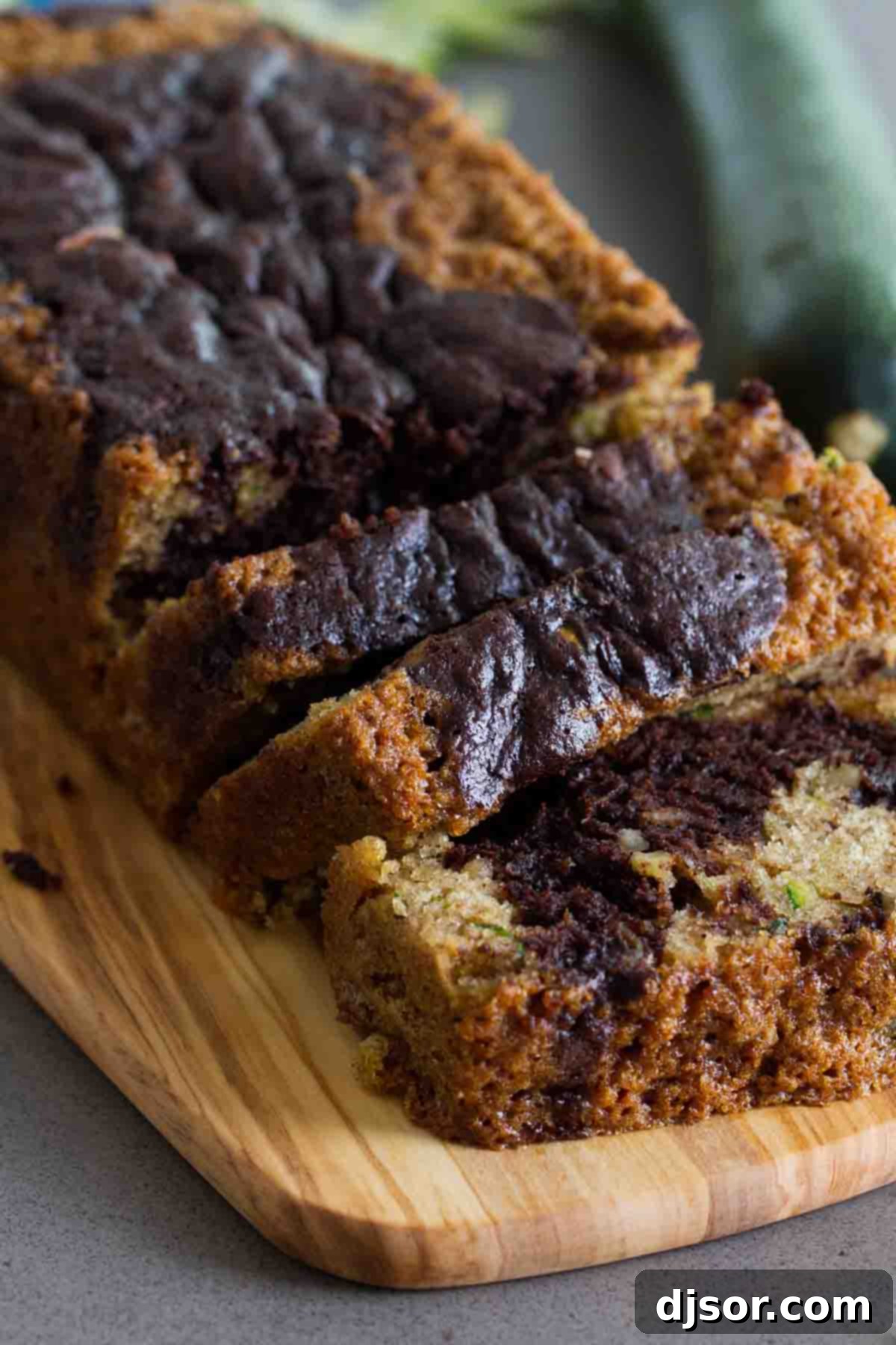 A perfectly sliced piece of Chocolate Wave Zucchini Bread on a cutting board, ready to be served