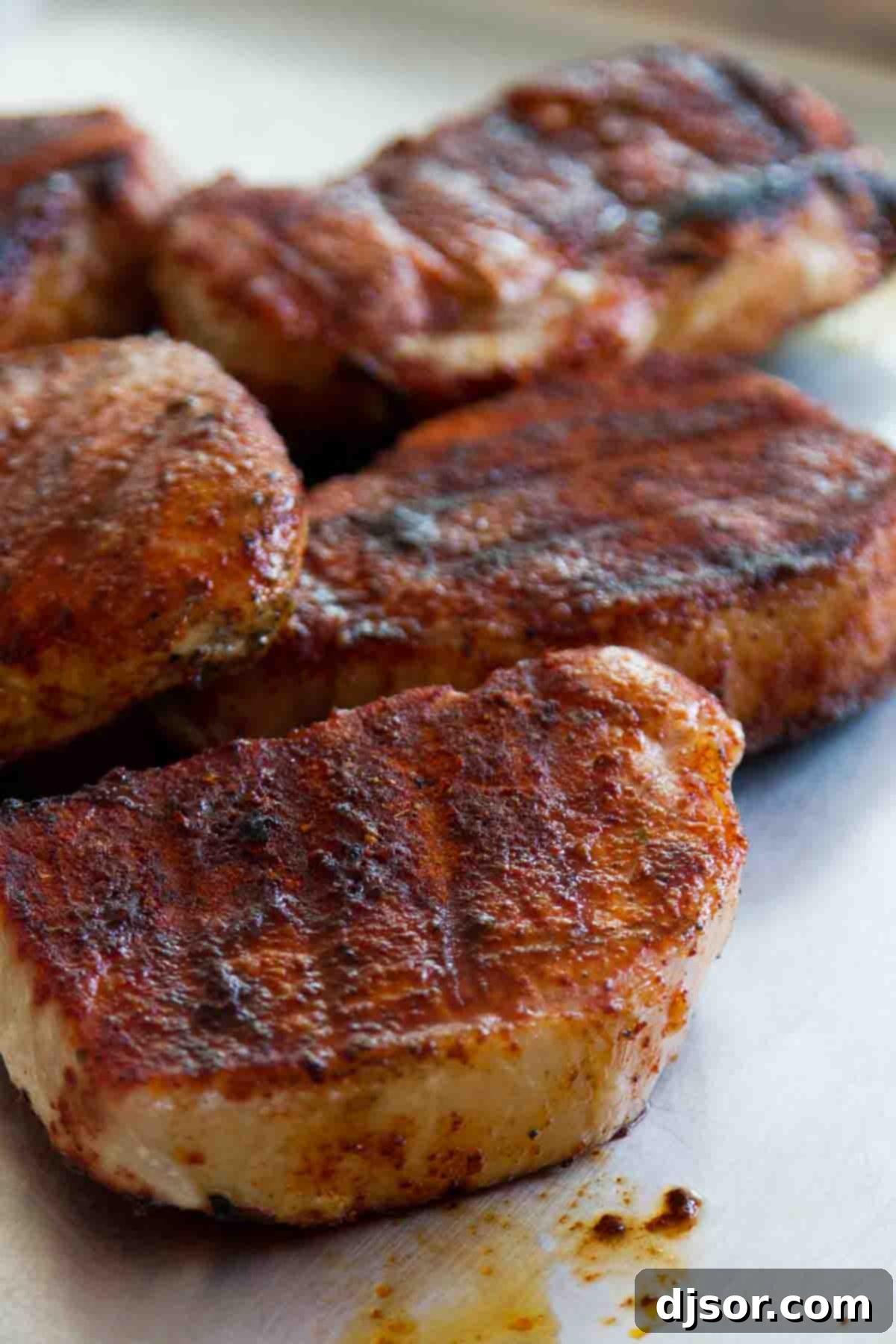 Close-up of a seasoned boneless pork chop, showcasing the rich, dark spice rub before grilling.