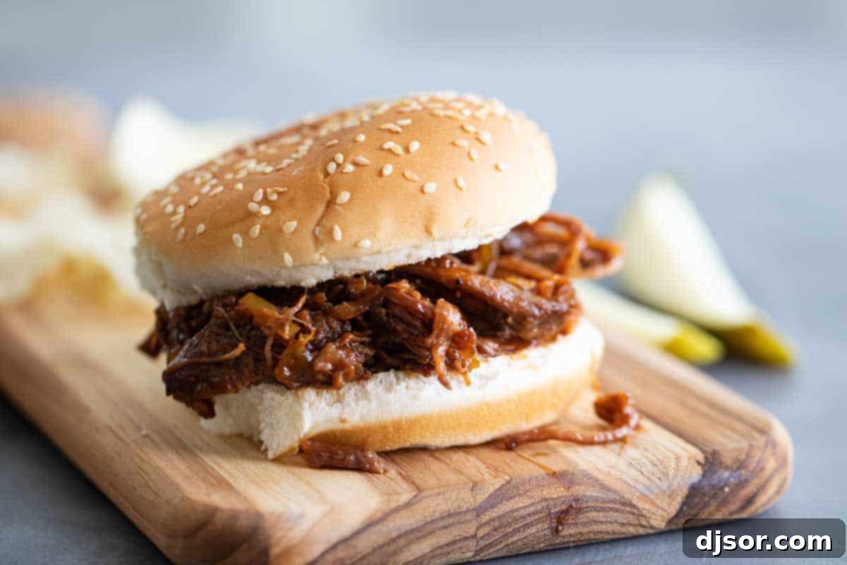 bbq beef sandwich on a wooden board with a side of coleslaw