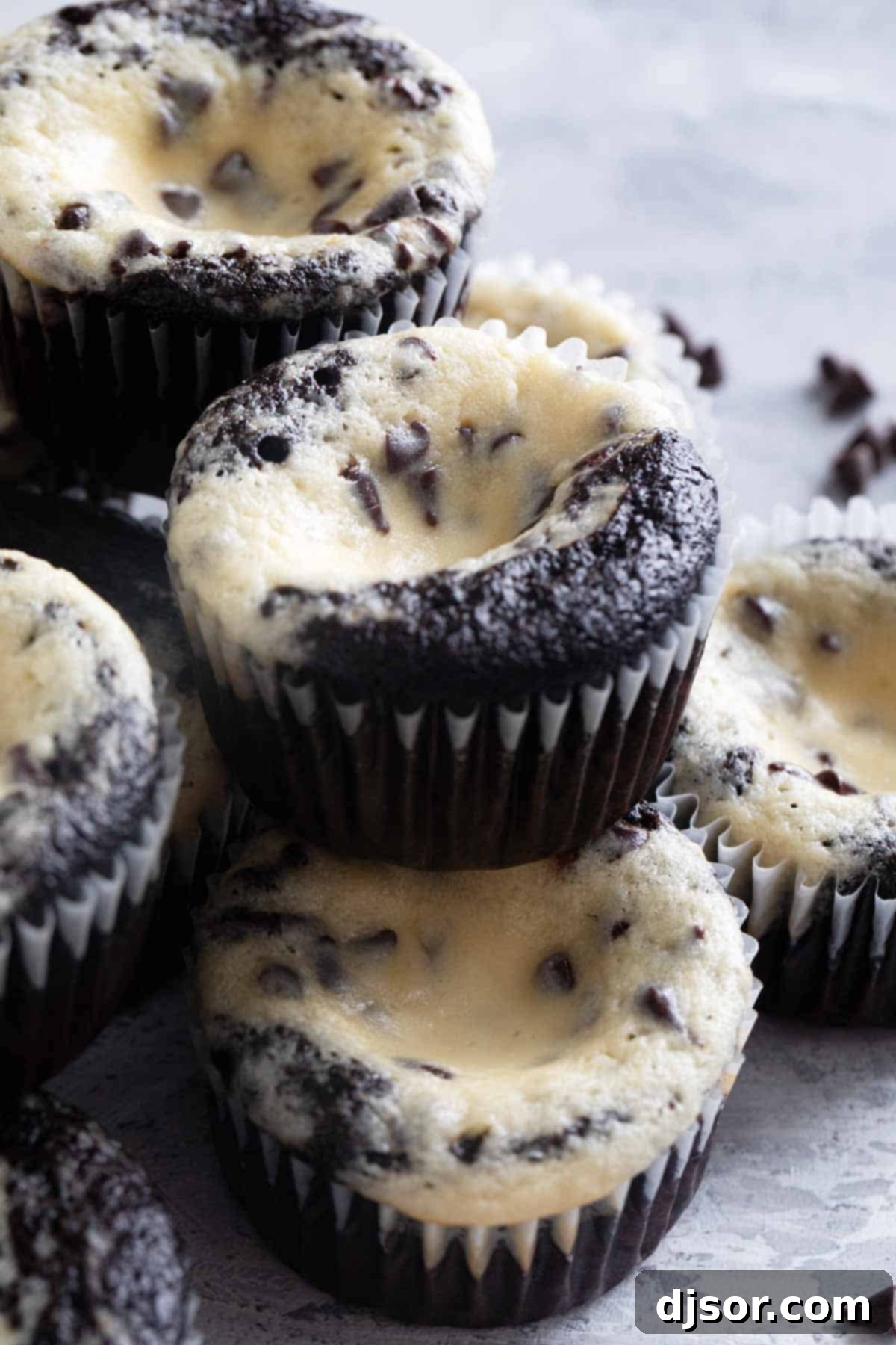 Black Bottom Cupcakes stacked on top of each other, showcasing the dark chocolate cake and creamy cheesecake top.