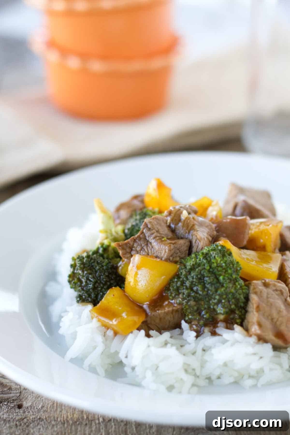 Hoisin Beef with Vegetables - an easy beef stir fry with hoisin sauce and lots of vegetables. Hoisin Beef with Vegetables over jasmine rice on a plate, garnished with green onions and sesame seeds, showcasing vibrant broccoli and bell peppers.