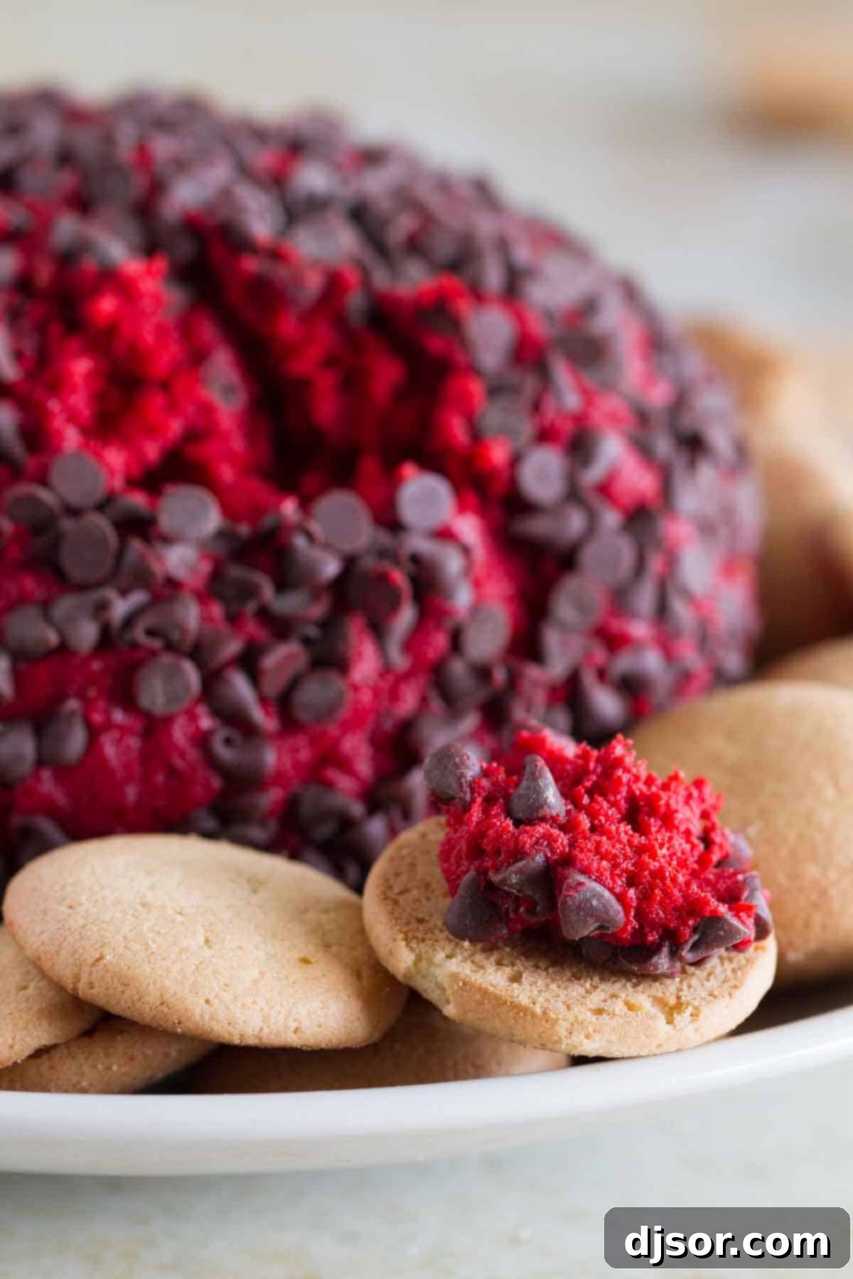 Velvet Red Cheese Truffles 4 Red Velvet Cheese Ball with some on a vanilla wafer, showing its creamy texture