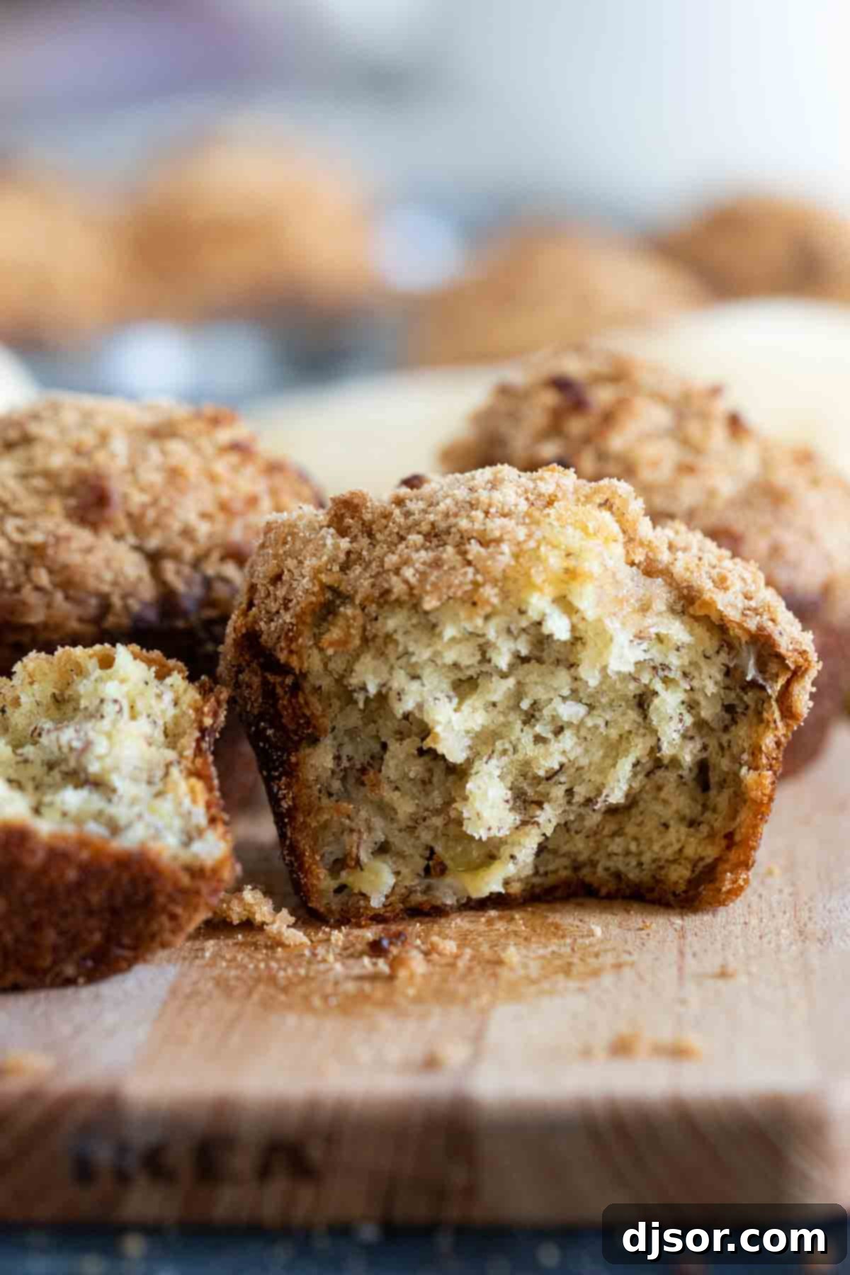 Cross-Section of a Delicious Banana Crumb Muffin Close-up of a banana muffin cut in half, revealing its moist interior and crunchy crumb topping.