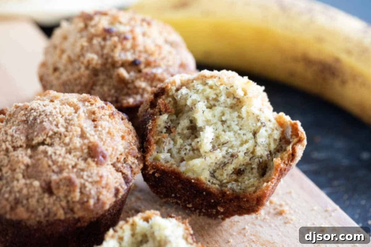 Freshly Baked Banana Muffins with Crumb Topping A basket full of golden-brown banana muffins with crumb topping, ready to be enjoyed.