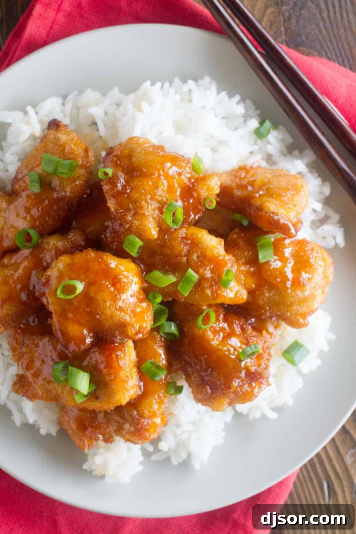 Sweet and sour chicken over rice with green onions.