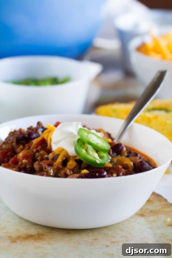 A hearty bowl of Warm You Up Beef and Bean Chili, garnished with fresh cilantro and a dollop of sour cream.