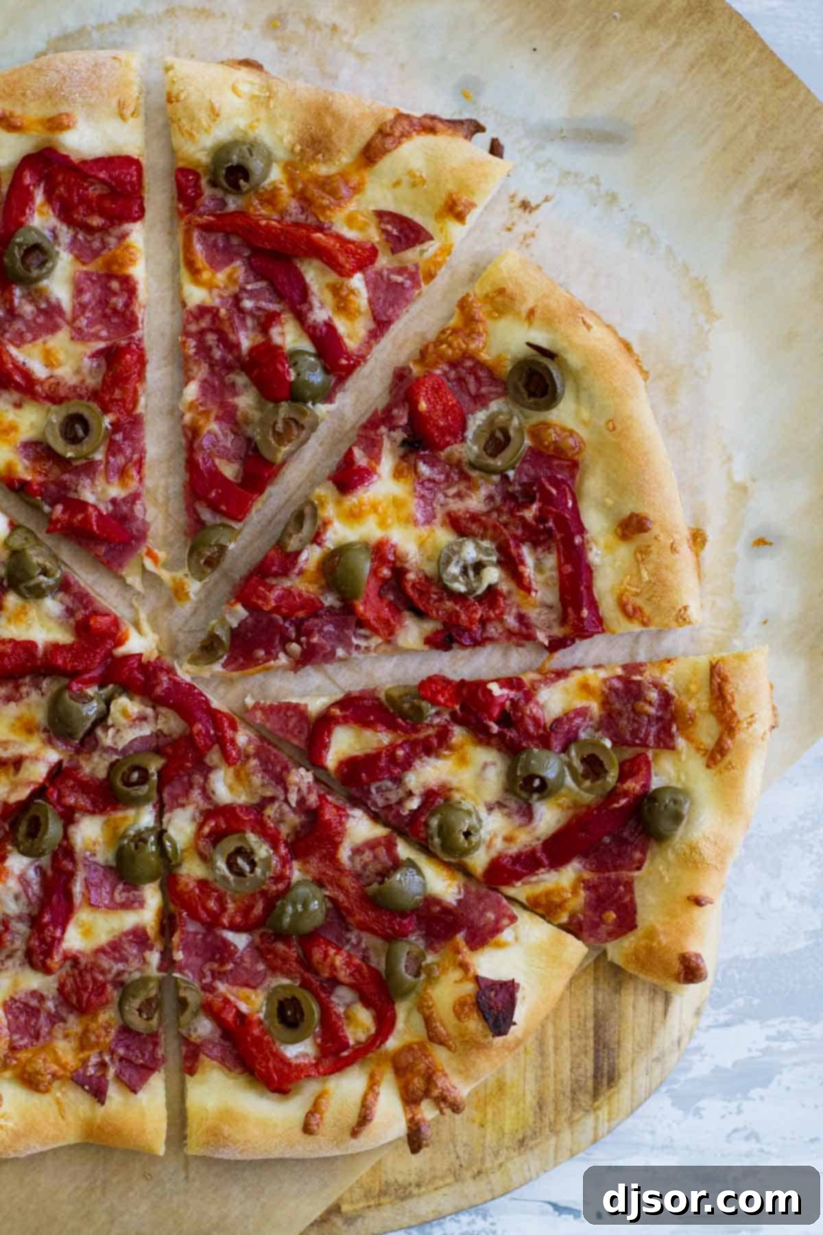 Antipasto Pizza: A Flavorful Italian Classic Reimagined Full Antipasto Pizza cut into delicious slices, showcasing salami, roasted red peppers, and olives.