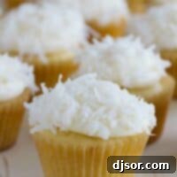 coconut cupcakes topped with cream cheese frosting and coconut