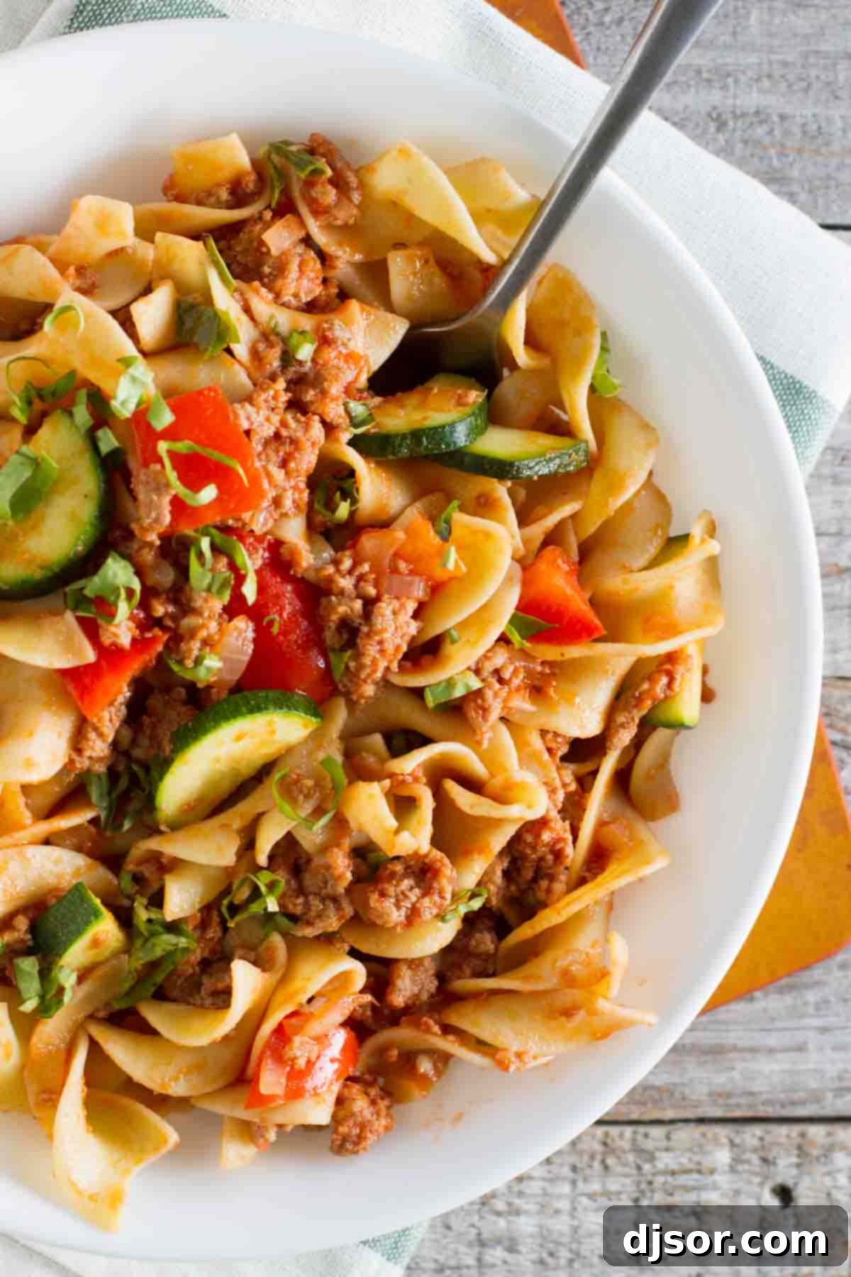 Overhead view of a comforting bowl of Turkey Goulash, showcasing the rich tomato sauce, tender ground turkey, and colorful vegetables mixed with egg noodles.