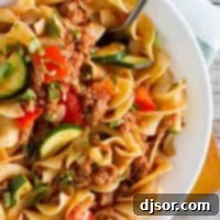 Overhead view of a comforting bowl of Turkey Goulash, showcasing the rich tomato sauce, tender ground turkey, and colorful vegetables mixed with egg noodles.
