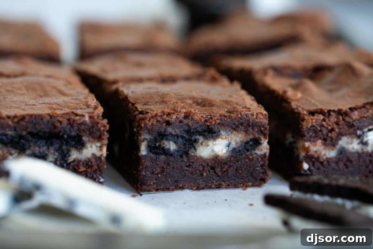 Perfectly sliced Oreo Brownies revealing the thick, creamy cookies and cream center